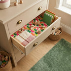 Colorful Christmas tree wrapping paper lining a nursery dresser drawer by Wrapped Studios.