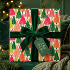 Modern Christmas wrapping paper with colorful trees and green velvet bow, by Wrapped Studios.