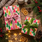 Colorful Christmas tree wrapping paper with pink and green ribbons on a cozy wooden table by Wrapped Studios.