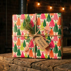 Modern Christmas tree wrapping paper by Wrapped Studios, styled with a rustic twine bow and gift tag.