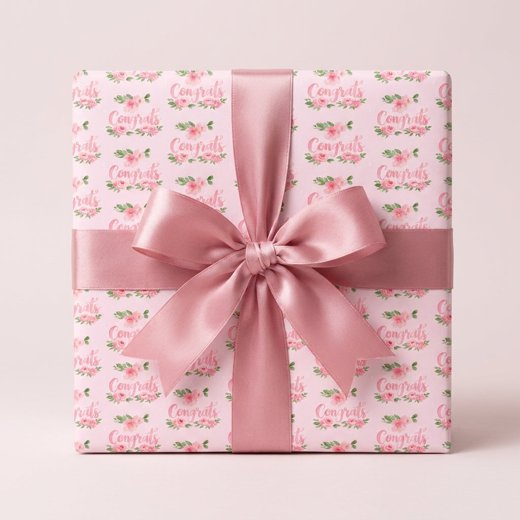 Pink floral congrats wrapping paper with a dusty rose satin bow, by Wrapped Studios.