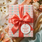 Congratulations wrapping paper with a coral satin bow and celebration gift tag by Wrapped Studios.