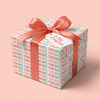 Congratulations wrapping paper with a coral satin bow and gift tag by Wrapped Studios.