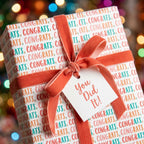 Congratulations wrapping paper from Wrapped Studios with coral velvet ribbon and a "You Did It!" tag.