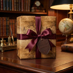 Luxury gift wrap with a vintage map design, tied with a burgundy satin ribbon bow in a stately home office setting.