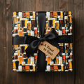 Square gift wrapped in beer-themed paper with black ribbon and "A Toast to You!" tag.