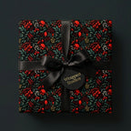 Wrapped Studios luxury gift wrapped in a dark floral Christmas wrapping paper with a black satin bow.