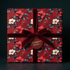 Wrapped Studios floral wrapping paper with velvet burgundy ribbon and gift tag.