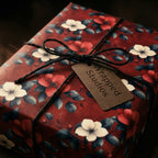 Elegant floral wrapping paper with red and white flowers. Finished with twine. Wrapped Studios.