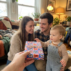 Toddler reaching for a birthday gift wrapped in cute cow wrapping paper by Wrapped Studios.