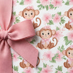 Cute monkey baby shower wrapping paper with pink floral pattern and ribbon bow, by Wrapped Studios.