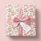 Pink monkey baby shower wrapping paper with floral pattern and satin bow by Wrapped Studios.