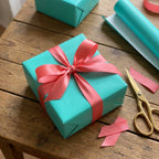 Cyan: Solid Color Wrapping Paper solid color wrapping paper on a square gift box with a pink satin ribbon bow.