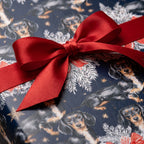 Dachshund Christmas wrapping paper with a red satin bow, festive dog gift wrap by Wrapped Studios.