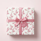 Elegant pink cherry blossom floral wrapping paper with a satin bow and tag from Wrapped Studios.