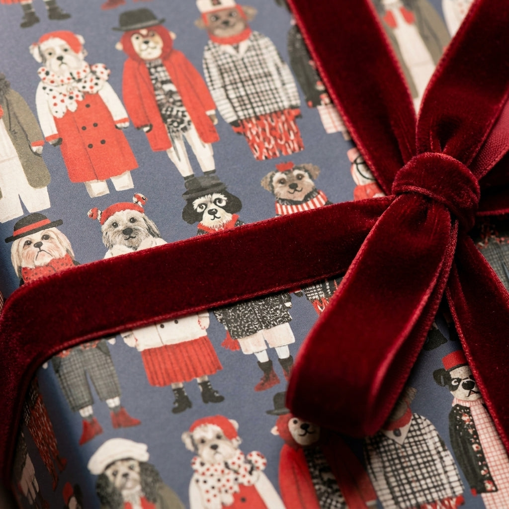 Cute dog Christmas wrapping paper tied with a luxury red velvet bow by Wrapped Studios.