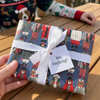 Cute dog Christmas wrapping paper with a white ribbon and a No Peeking tag by Wrapped Studios.