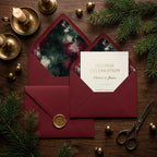 Burgundy Christmas invitation suite with gold wax seal and artistic envelope liners by Wrapped Studios.