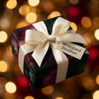 Elegant Christmas wrapping paper by Wrapped Studios with cream ribbon and warm holiday bokeh lights.