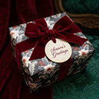 Luxury vintage Christmas wrapping paper with floral pattern and red velvet bow by Wrapped Studios.