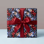 Luxury Christmas gift wrap with blue botanical berry pattern and red satin bow by Wrapped Studios.