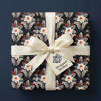 Luxury Christmas wrapping paper with elegant floral pattern and cream satin bow by Wrapped Studios.