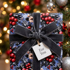 Luxury Christmas gift wrap with a botanical red berry pattern and grey velvet bow by Wrapped Studios.