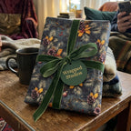 Luxury Christmas wrapping paper with pinecones and green velvet ribbon by Wrapped Studios.
