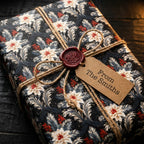 Vintage floral Christmas wrapping paper with twine, wax seal, and gift tag by Wrapped Studios.