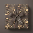 Vintage floral wrapping paper with cream botanical print and a brown ribbon, by Wrapped Studios.