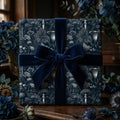 Luxury dark botanical wrapping paper with a navy velvet bow by Wrapped Studios.