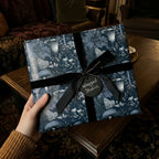 Moody botanical wrapping paper with mushrooms and moths, tied with a black velvet bow by Wrapped Studios.