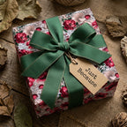 Vintage botanical wrapping paper with mushrooms, red flowers, and a green ribbon. Wrapped Studios.