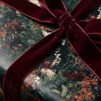 Luxury botanical floral wrapping paper with a burgundy velvet ribbon bow by Wrapped Studios.