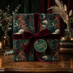 Luxury dark floral wrapping paper with a burgundy velvet bow on a gift box, by Wrapped Studios.