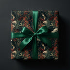 Moody floral wrapping paper with a forest green satin bow on a luxury gift box by Wrapped Studios.