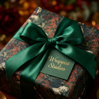 Luxury dark floral wrapping paper with emerald green satin bow and Wrapped Studios gift tag.