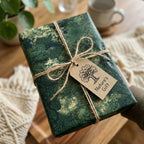 Green forest botanical wrapping paper with a rustic twine bow, from Wrapped Studios.