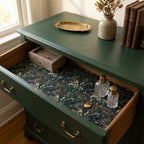 Dark vintage floral wrapping paper used as a drawer liner in a green dresser by Wrapped Studios.