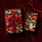Luxury dark floral wrapping paper with red poppies and ribbon on red velvet by Wrapped Studios.