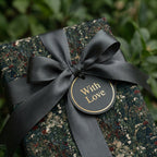 Vintage floral wrapping paper with a black satin bow and 'With Love' gift tag by Wrapped Studios.