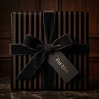 Elegant gift box wrapped in striped wrapping paper with a velvet bow and "For Him" tag.