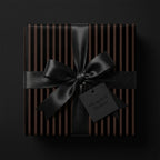 Elegant gift with black ribbon and striped modern wrapping paper for luxury gift-giving.