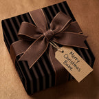 Striped black & brown Christmas gift wrap with a brown ribbon bow and a "Merry Christmas Babe" tag.