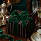 Elegant black striped gift box with a lush green velvet ribbon, ideal luxury gift wrap.