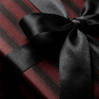 Burgundy and black striped gift wrap with elegant black satin ribbon bow.