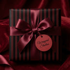 Elegant gift box with vertical striped wrapping paper and burgundy satin ribbon.