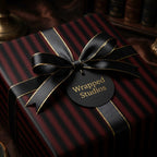 Elegant gift wrapped in striped burgundy wrapping paper with a black and gold ribbon bow.