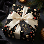Gift box wrapped in black "Winter Whiskers" wrapping paper with cat and tree design, tied with ivory ribbon.
