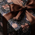 Luxury Christmas gift wrap with vintage pine and ornament pattern, brown satin bow by Wrapped Studios.